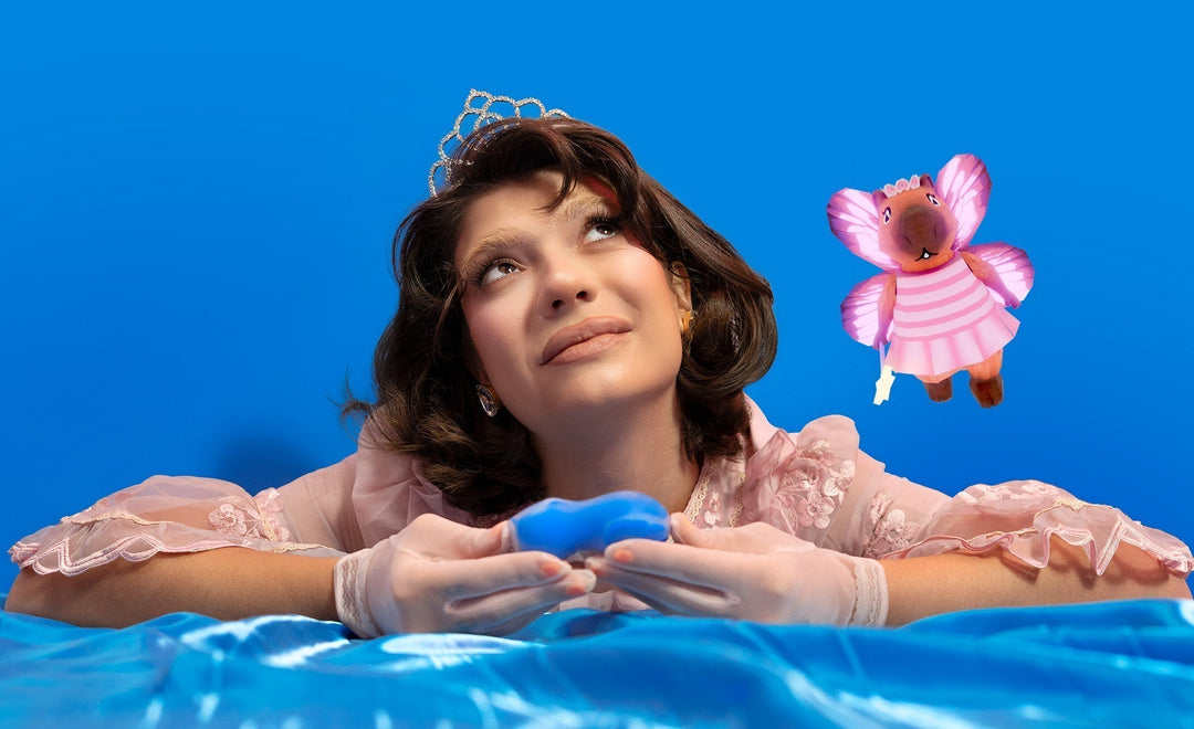 Mulher segurando um sugador de clitóris da Toyart com elementos lúdicos ao fundo.